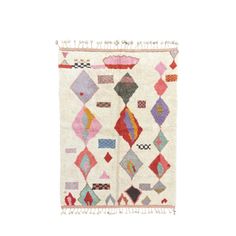 a white rug with colorful geometric designs and fringes on the bottom, in front of a