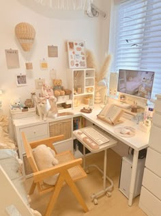 a white desk topped with a computer monitor next to a wooden chair near a window