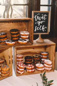 several wooden boxes filled with donuts on top of a table