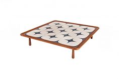 a square coffee table with black and white dots on the top, against a white background