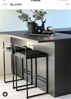 two stools sit at the counter in front of a vase with flowers on it