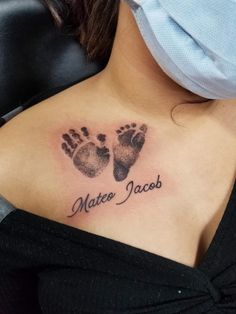 a woman with a tattoo on her chest that says, mater jacobo and two baby footprints