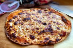 a pizza sitting on top of a wooden cutting board