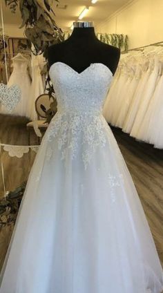 a white wedding dress on display in a store