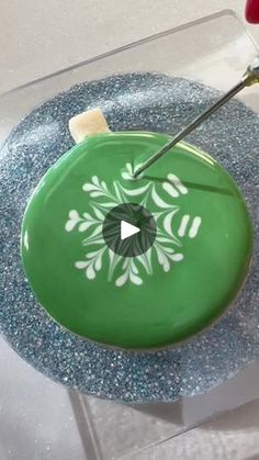 a green cake with white designs on it and a knife sticking out of the top