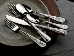 three forks and two knives on a plate