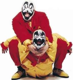 two clowns are sitting on the ground with their mouths open