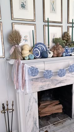 a mantel decorated with blue and white dishes, candles, and other decorative items