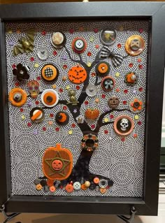 a black frame with an orange and white tree on it that has buttons all over it