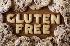 the word gluten free spelled out with cookies and crackers on a wooden surface