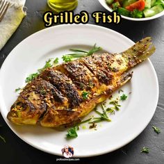 grilled fish is served on a white plate