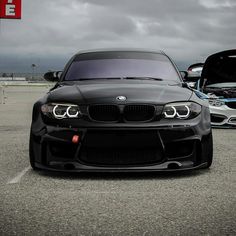 the front end of a black car parked in a parking lot