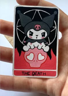 a person holding up a tarot card with a cat on it