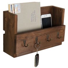 a wooden phone holder with keys and other items hanging from it's hooks on a white background