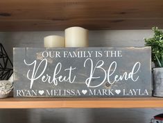 a wooden sign that says our family is the perfect blend with hearts and two candles