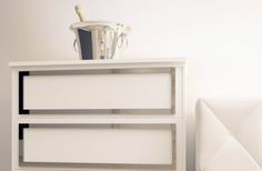 a white cabinet with two drawers and a blender on top, in a room