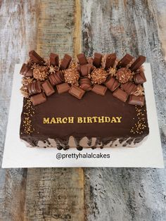 a birthday cake with chocolate frosting and gold sprinkles on the top