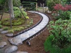 a garden with rocks and plants around it