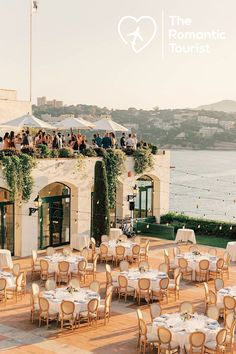 an outdoor dining area with tables and chairs set up for a wedding reception overlooking the water