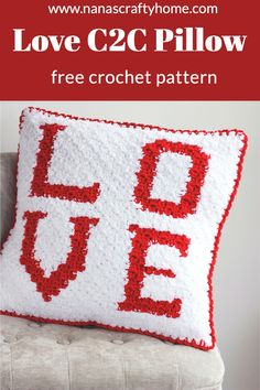 a crocheted pillow with the words love and two letters in red on it