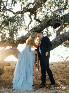 a man and woman kissing under a tree