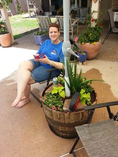 a woman sitting in a chair with potted plants