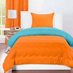 an orange and blue comforter on a white bed