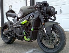 a black motorcycle parked in front of a garage