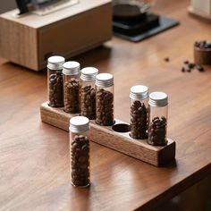 six jars with nuts in them on a wooden table