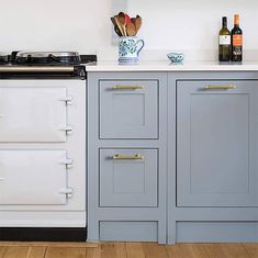 a white stove top oven sitting inside of a kitchen next to a counter with wine bottles on it