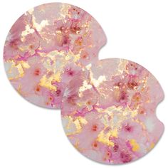 two round pink and gold coasters on a white background, each with an abstract design