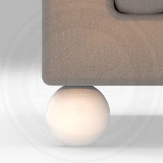 a white ball sitting on top of a couch next to a gray chair and ottoman