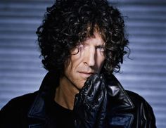 a man with curly hair wearing a black leather jacket