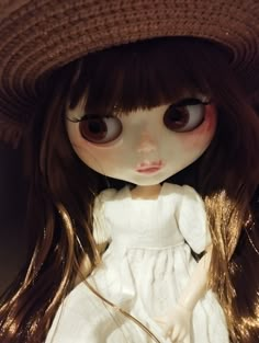 a doll with long hair wearing a hat