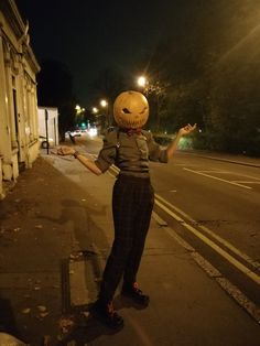 a person wearing a jack o lantern mask on the street