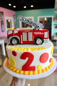 a birthday cake with a firetruck on top that says 2 o'clock