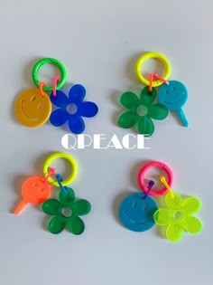 four different colored plastic keychains with smiley faces and flowers attached to each other