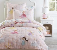 a bed with princess comforter and pillows on it