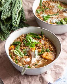 two bowls of lentula soup with spinach leaves