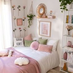 a bed with pink and green pillows in a bedroom next to a white book shelf