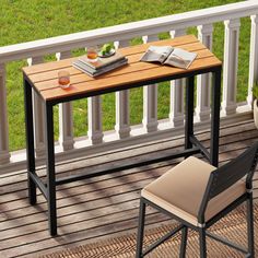 an outdoor table with two chairs and a book on it next to a balcony railing