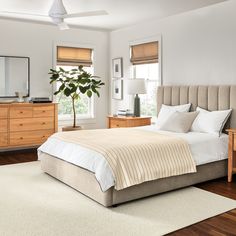 a bedroom with a bed, dressers and mirror in it's center area