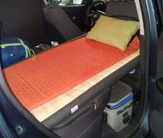 an orange sleeping bag in the back of a car