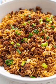 a white bowl filled with noodles and meat