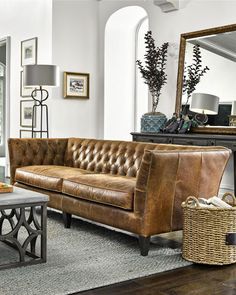 a living room filled with furniture and a large mirror on the wall above it's headboard