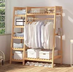 a wooden shelf with clothes and shoes on it in a room next to a window