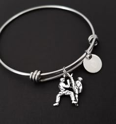 a silver bracelet with an image of two people on it and a disc in the middle