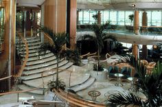 the inside of a large building with stairs and plants in it's center area