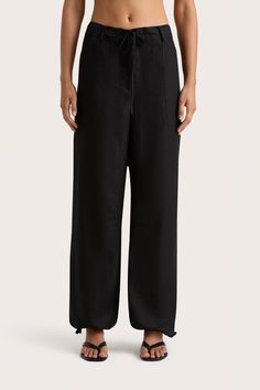 A relaxed 100% European Flax® linen trouser in Black with patch-style pockets. Sitting mid-rise above the hips, it has a paper bag drawstring waist and drawstrings at the cuff, allowing for a custom fit. Wear over swim for casual beach to bar wear. Black Drawstring Summer Pants, Black Linen Wide Leg Pants, Black Linen Pants For Loungewear, Black Beach Pants With Elastic Waistband, Black Linen Wide Leg Pants With Elastic Waistband, Black Cotton Parachute Pants With Side Pockets, Black Linen Wide-leg Pants, Black High-waisted Parachute Pants With Drawstring, Patches Fashion