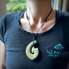 This picture shows a carved Matau, Hook, in New Zealand Jade. It is a hook shaped pendant pendant that culminates in a fish tail. It is provided with a black coloured cord that is length adjustable. Hand made in New Zealand by Andrew Doughty. Jade Jewellery, Hook Necklace, Hook Design, Art To Wear, Bone Carving, Jade Jewelry, The Fish, Fish Hook, Traditional Art